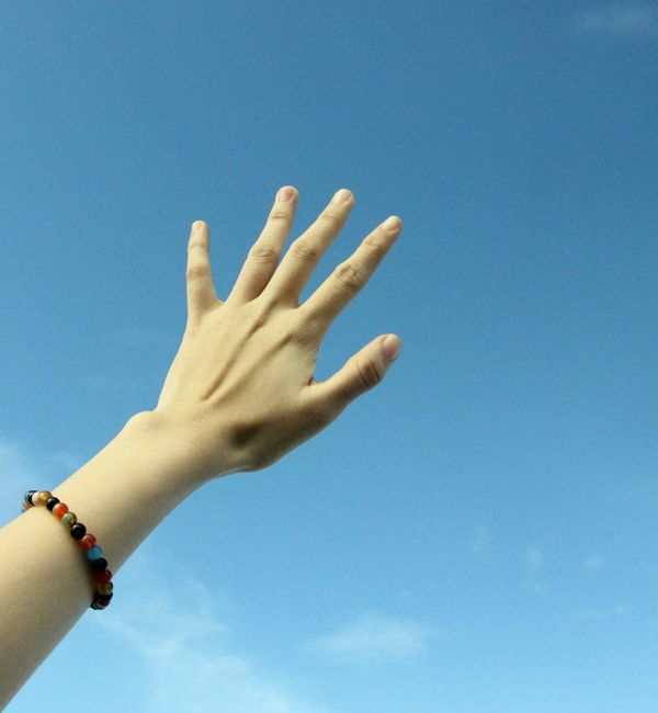 Person feeling energized and stretching towards the sky in nature.